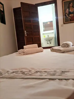 a bedroom with two beds and a door with a window at Riad Oued Issil in Marrakech