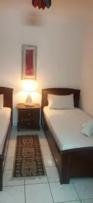 a bedroom with two beds and a lamp on a table at Riad Oued Issil in Marrakech