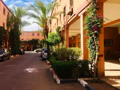 a street in front of a building with palm trees at Riad Oued Issil in Marrakech