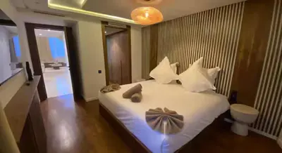 a bedroom with a bed with white sheets and pillows at Luxueux Duplex 3 chambres à Victor Hugo in Marrakech