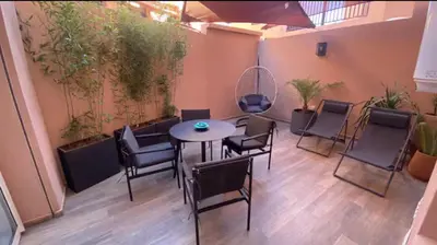 a room with a table and chairs and plants at Luxueux Duplex 3 chambres à Victor Hugo in Marrakech