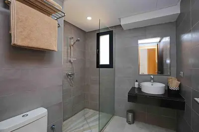 a bathroom with a glass shower and a sink at Elegant and Modern appart hôtel with Best location in Marrakech