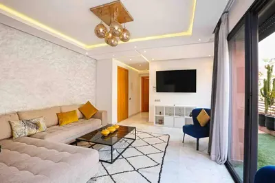 a living room with a couch and a tv at Elegant and Modern appart hôtel with Best location in Marrakech