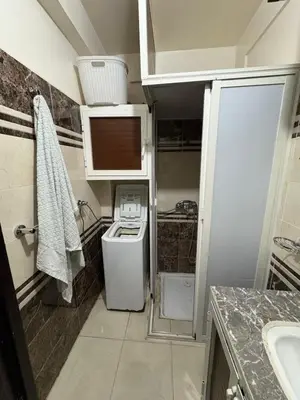 a small bathroom with a washer and dryer in it at Family flat in Marrakech in Marrakech