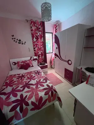 a bedroom with a bed with a red and white comforter at Family flat in Marrakech in Marrakech