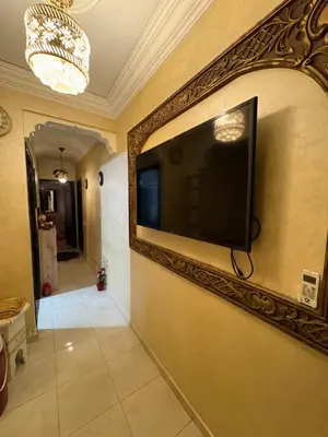 a flat screen tv on a wall with a mirror at Family flat in Marrakech in Marrakech