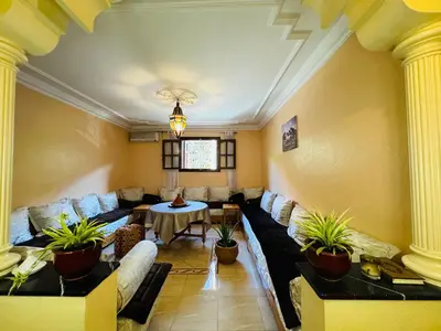 a living room with couches and a table and potted plants at B and b in our house in Marrakech