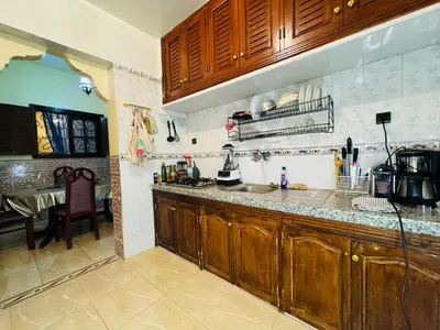a kitchen with wooden cabinets and a table in it at B and b in our house in Marrakech