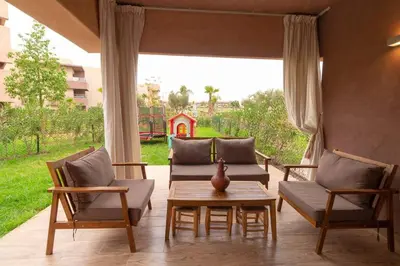 a patio with two chairs and a table and a couch at Peaceful apartment with a garden in Marrakech