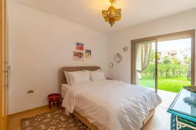 a bedroom with a bed and a large window at Peaceful apartment with a garden in Marrakech