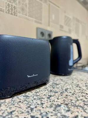 a black microwave sitting on a counter next to a coffee mug at Yumo - Cozy 2 in Marrakech