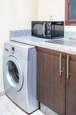 a microwave sitting on a counter next to a washing machine at Zen & Chic - Marrakech Downtown in Marrakech