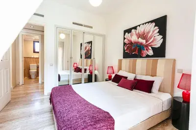 a bedroom with a large white bed with red pillows at Zen & Chic - Marrakech Downtown in Marrakech