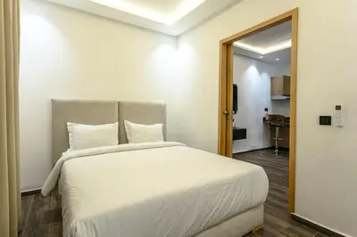 a bedroom with a white bed and a mirror at L'Eden Suite - Marrakech Centre in Marrakech