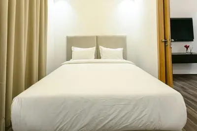 a bed with white sheets and pillows in a room at L'Eden Suite - Marrakech Centre in Marrakech