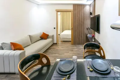 a living room with a couch and a table and chairs at L'Eden Suite - Marrakech Centre in Marrakech