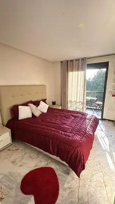 a bedroom with a large red bed with a large window at Heart of Marrakech city center - Gueliz in Marrakech