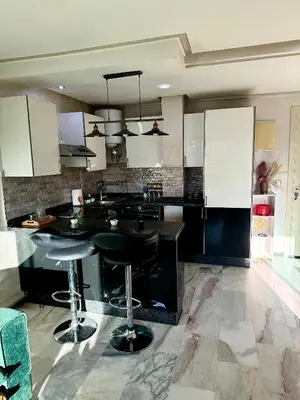 a kitchen with black counter tops and bar stools at Heart of Marrakech city center - Gueliz in Marrakech