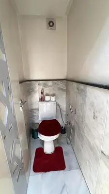 a bathroom with a toilet with a red seat at Heart of Marrakech city center - Gueliz in Marrakech