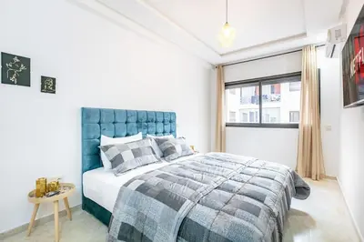 a bedroom with a blue bed and a window at Appartement chic et moderne in Marrakech