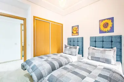 a bedroom with two beds and a yellow door at Appartement chic et moderne in Marrakech