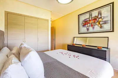 a bedroom with a large white bed and a dresser at Serene Oasis Pool & Garden View in Marrakech