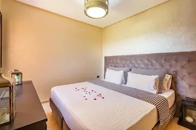 a bedroom with a bed with red rose petals on it at Serene Oasis Pool & Garden View in Marrakech