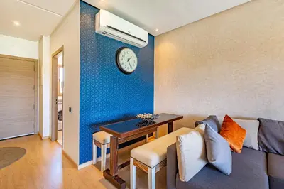a living room with a couch and a clock on a wall at Serene Oasis Pool & Garden View in Marrakech