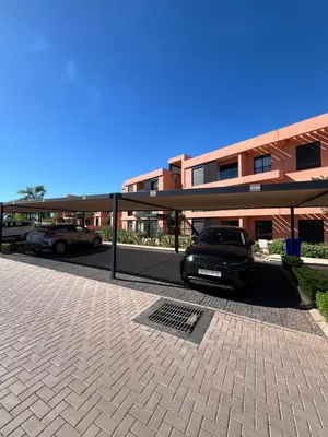 a car parked in a parking lot next to a building at Cozy Urbain Appartement in Marrakech