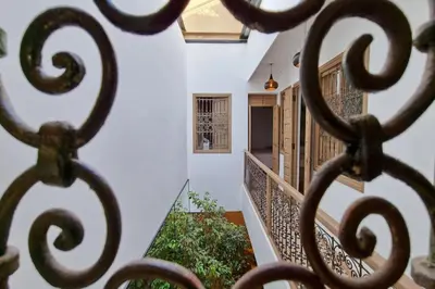 a view through a iron gate of a stairway at Riad Ouladi -Exclusif - 5mn Jemaa El Fnaa -Pool in Marrakech