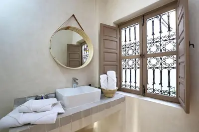 a bathroom with a sink and a mirror and a window at Riad Ouladi -Exclusif - 5mn Jemaa El Fnaa -Pool in Marrakech