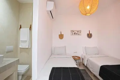 a small room with two beds and a bathroom at Riad Ouladi -Exclusif - 5mn Jemaa El Fnaa -Pool in Marrakech
