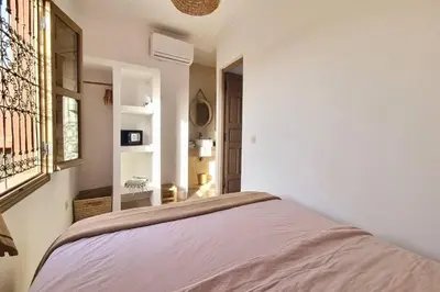 a white bedroom with a bed and a window at Riad Ouladi -Exclusif - 5mn Jemaa El Fnaa -Pool in Marrakech