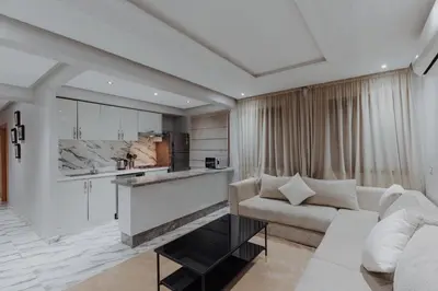 a living room with a couch and a kitchen at Zenitude séjournez en plein coeur de Marrakech in Marrakech