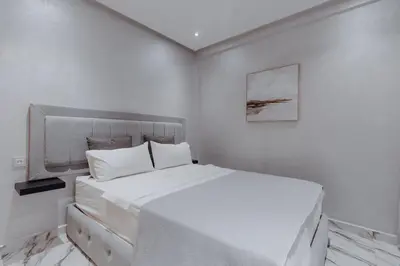 a white bedroom with a large white bed in it at Zenitude séjournez en plein coeur de Marrakech in Marrakech