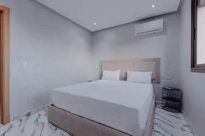 a white bedroom with a large white bed in it at Zenitude séjournez en plein coeur de Marrakech in Marrakech