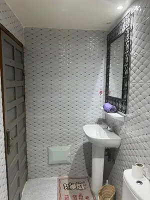 a white bathroom with a sink and a mirror at TOP couple apartment in Marrakech