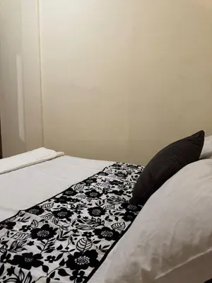 a bed with a black and white blanket on it at TOP couple apartment in Marrakech