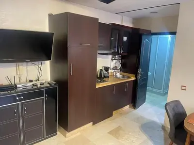 a kitchen with brown cabinets and a tv in it at Appartement de Lux,Guèliz in Marrakech
