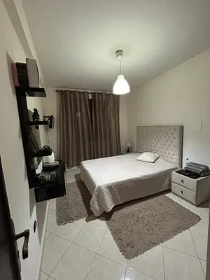 a white bedroom with a bed and a window at Appartement de Lux,Guèliz in Marrakech