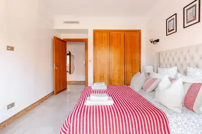 a bedroom with a bed with a red and white striped blanket at Appartement au cœur de Marrakech in Marrakech