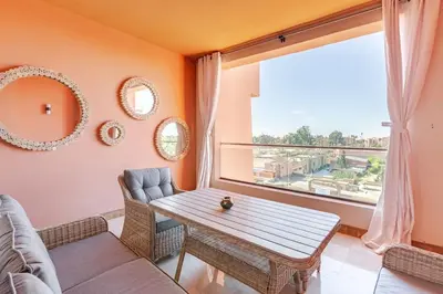 a living room with a table and a large window at Appartement au cœur de Marrakech in Marrakech