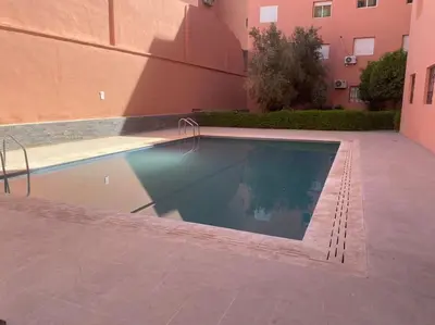 a swimming pool in front of a building at Spacieux Studio by Nina in Marrakech