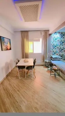 a living room with a table and a bed at Spacieux Studio by Nina in Marrakech
