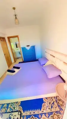 a room with a large bed with purple pillows at Spacieux Studio by Nina in Marrakech