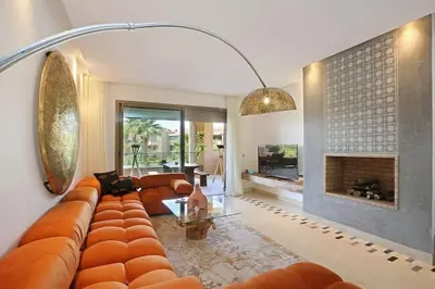 a living room with a couch and a fireplace at GOLF PRESTIGIA Résidence TOPAZE in Marrakech