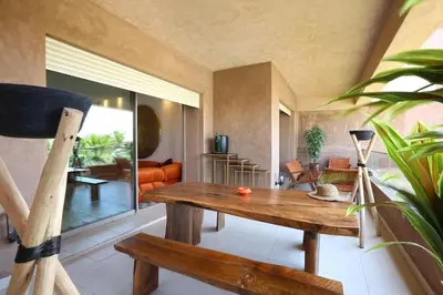 a living room with a wooden table and a couch at GOLF PRESTIGIA Résidence TOPAZE in Marrakech