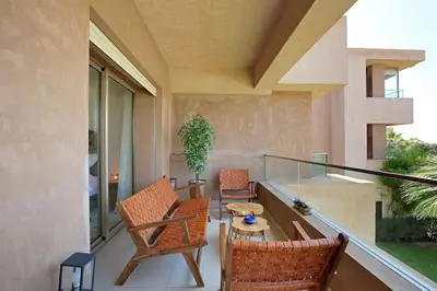 a balcony with two chairs and a table at GOLF PRESTIGIA Résidence TOPAZE in Marrakech