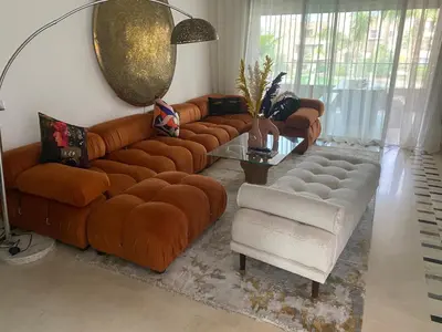 a living room with brown leather couches and a table at GOLF PRESTIGIA Résidence TOPAZE in Marrakech