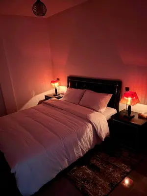 a bedroom with a large white bed with two lamps at Appartement familiale top one saada in Marrakech
